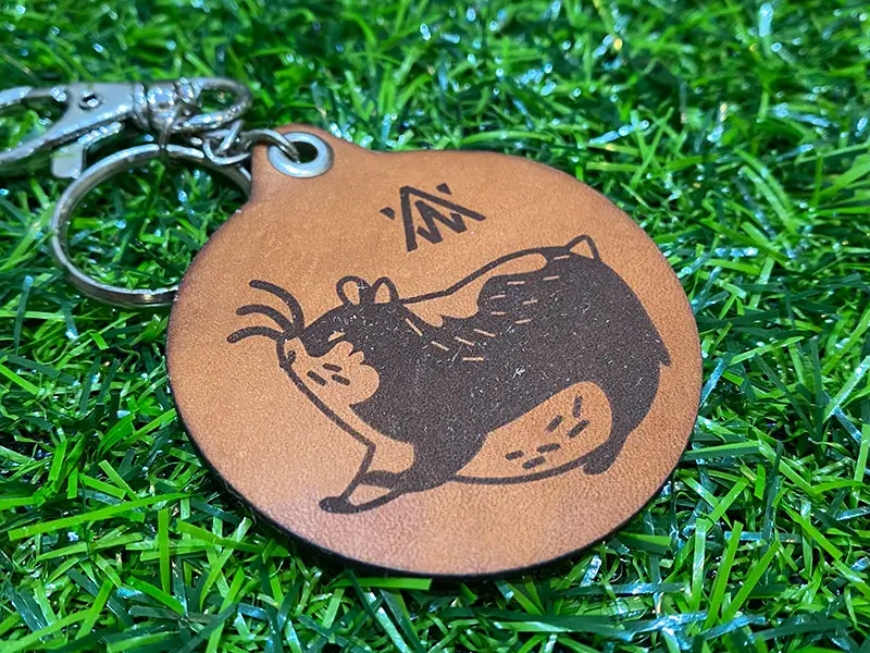 皮革雷射雕刻成品示意，文字與圖案呈現自然燒灼對比效果